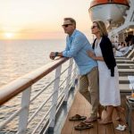 Couple relaxing on cruise ship deck at sunset