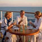 Luxury cruise deck guests at sunset