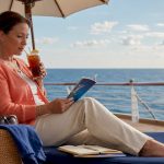 Woman planning all-inclusive cruise vacation on balcony