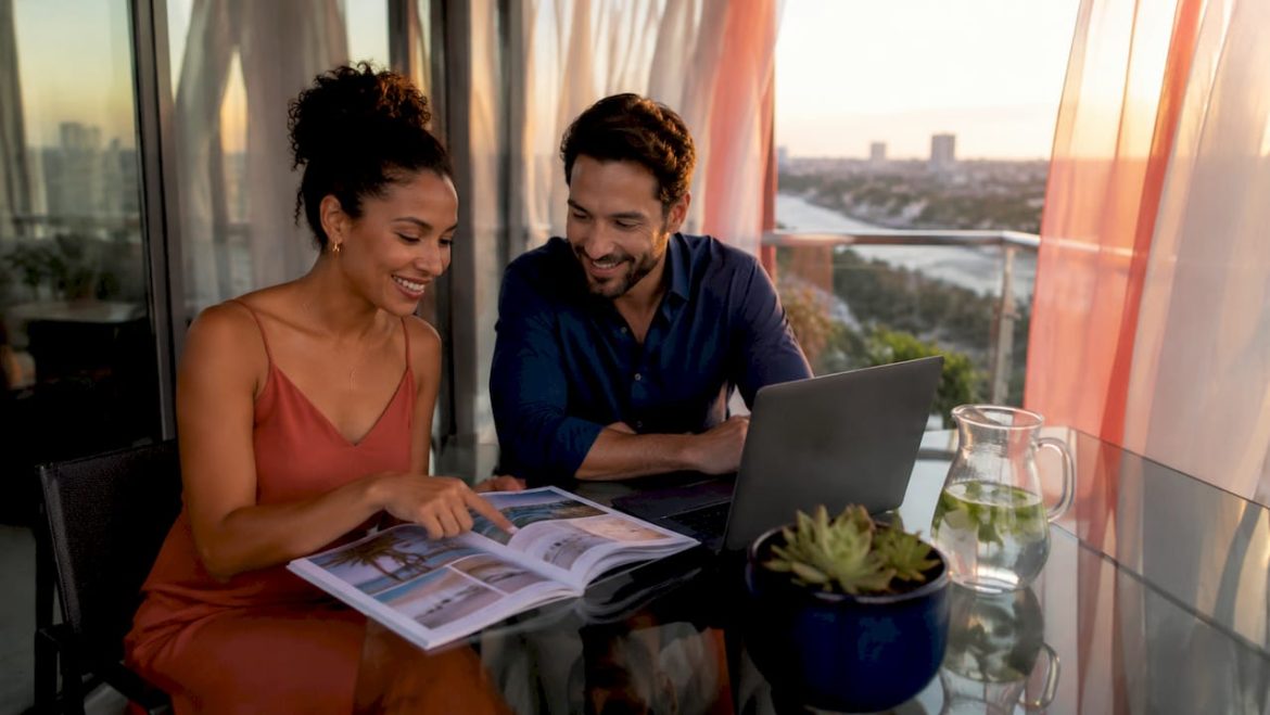 Couple planning honeymoon destinations at home