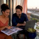 Couple planning honeymoon destinations at home