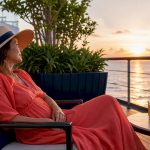 Woman relaxing on luxury cruise ship deck at sunset