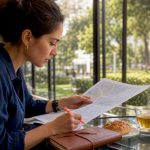 Woman planning travel itinerary at home table