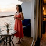 Woman enjoying VIP cruise balcony at sunset