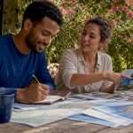 Couple planning honeymoon at kitchen table