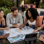 Friends planning group honeymoon around table