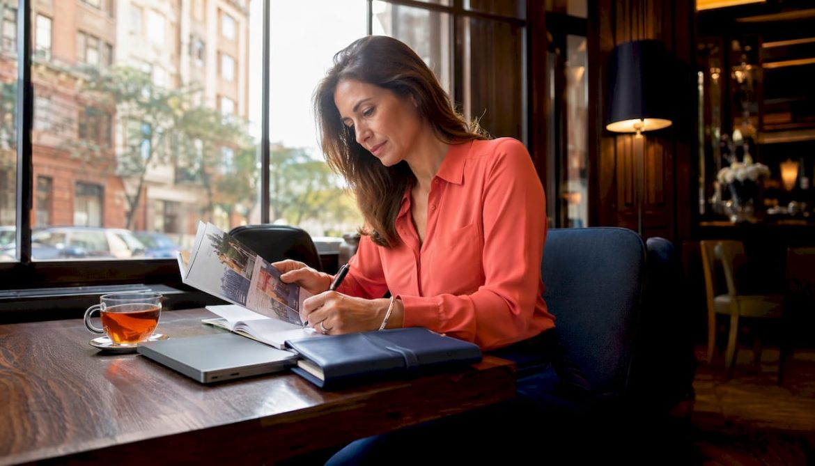 Luxury travel planner reviewing brochures at desk