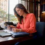 Luxury travel planner reviewing brochures at desk