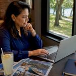 Woman booking cruise fare on laptop