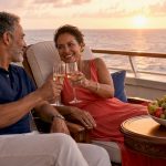 Couple enjoying romantic luxury cruise deck at sunset