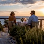 Luxury terrace table set for romantic anniversary meal with ocean view
