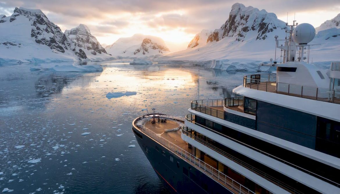 Luxury expedition ship by Antarctic glacier
