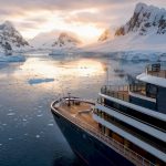 Luxury expedition ship by Antarctic glacier