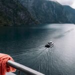 Luxury vessel cruising beneath Norwegian fjord mountains