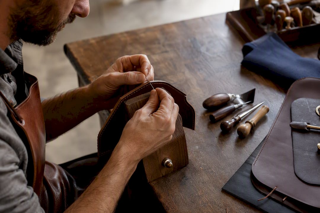 Artisan stitching leather in Florence workshop