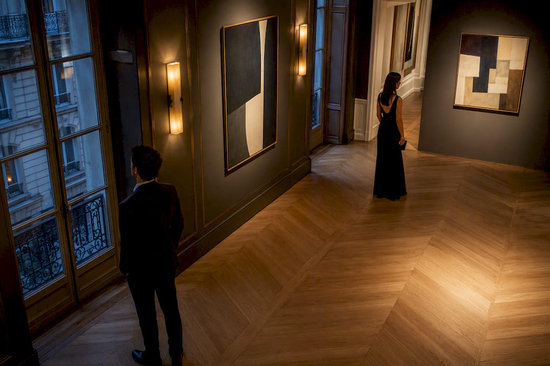 Guests viewing art in private Paris gallery