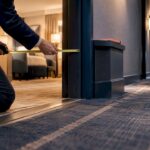 Inspector measuring hotel doorway accessibility