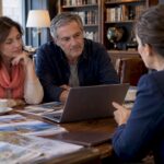 Couple comparing travel booking options with advisor