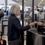 Traveler presenting REAL ID at airport checkpoint