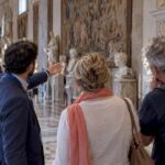 Guide leading a couple through Vatican Museums