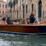 Private wooden launch traveling through Venice canal