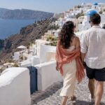 Honeymoon couple walking above Santorini’s caldera